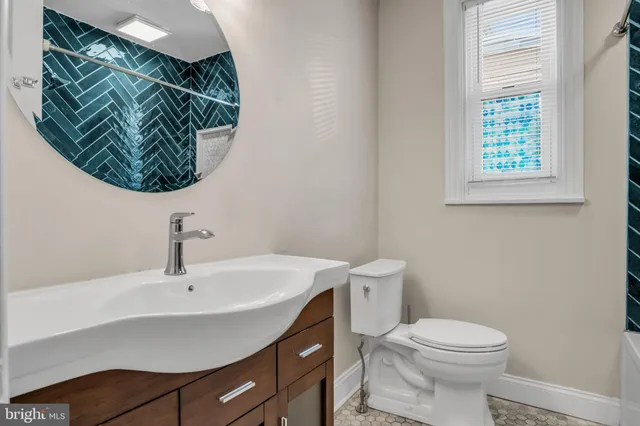 a bathroom with a sink a toilet and a window