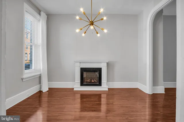 wooden floor fireplace and windows in an empty room
