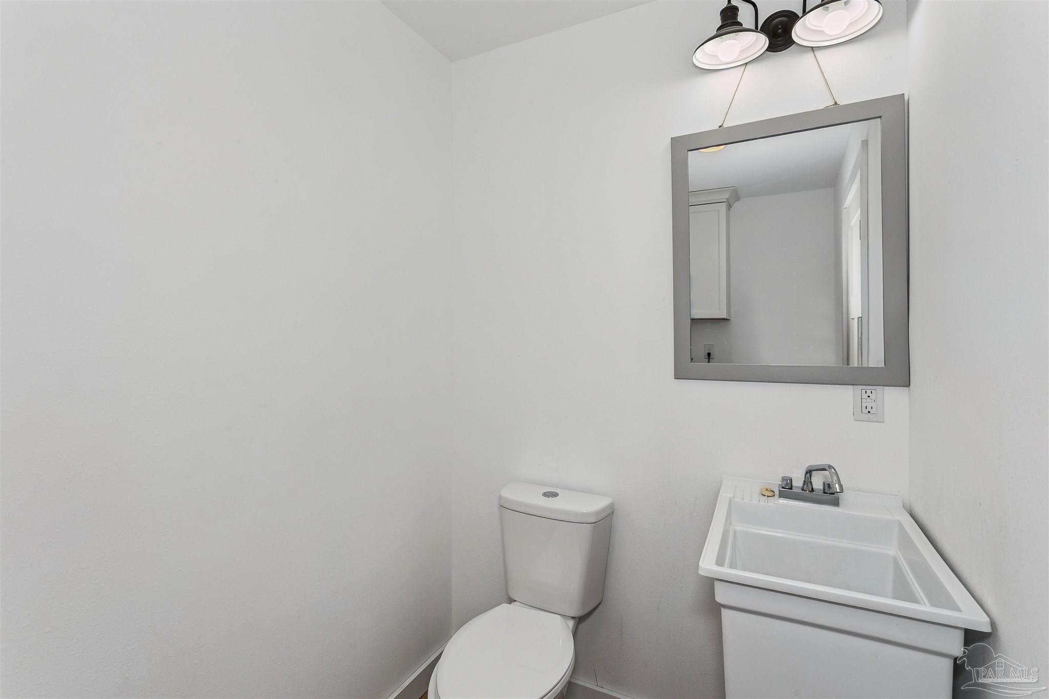 1095 River Annex Road Cantonment, FL 32533 - Photo 15 of 32 a bathroom with a toilet sink and mirror