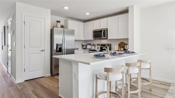 a kitchen with stainless steel appliances a refrigerator sink and microwave