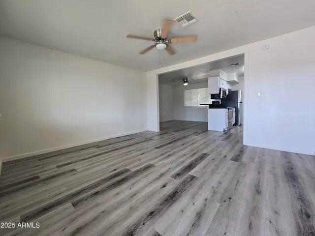 a view of empty room with wooden floor