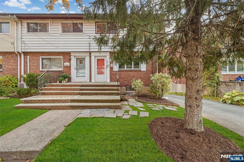 a front view of a house with a garden and yard