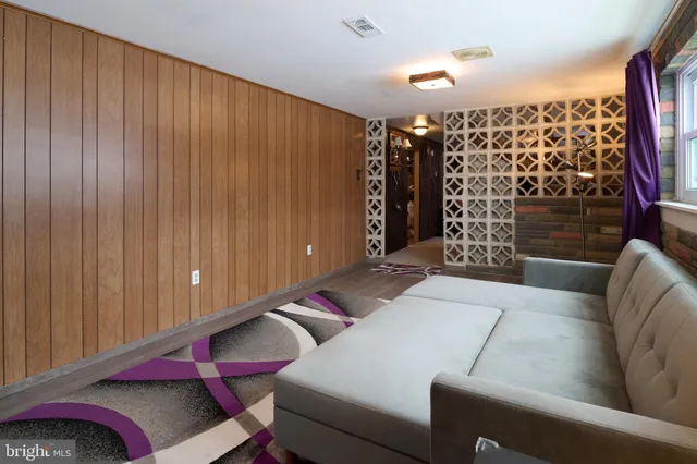 a bedroom with a bed and a flat tv screen on dresser