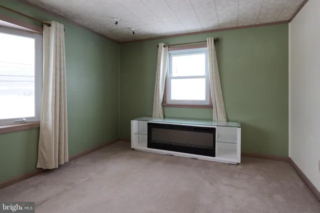 an empty room with windows and chandelier