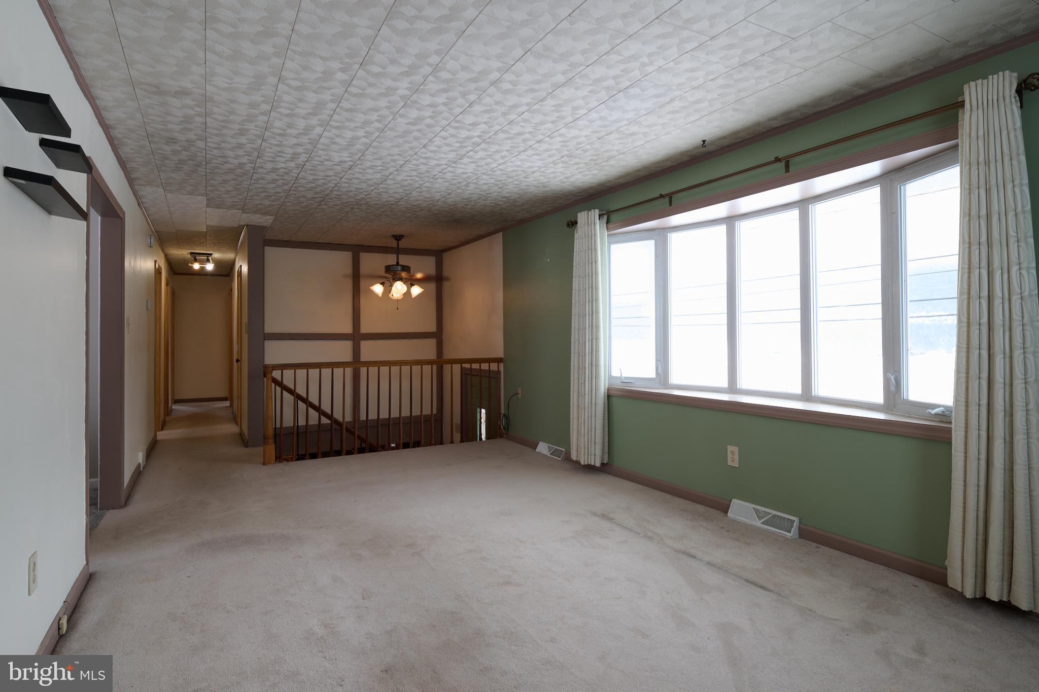 574 Buffalo Run Road Bellefonte, PA 16823 - Photo 32 of 54 an empty room with windows and chandelier