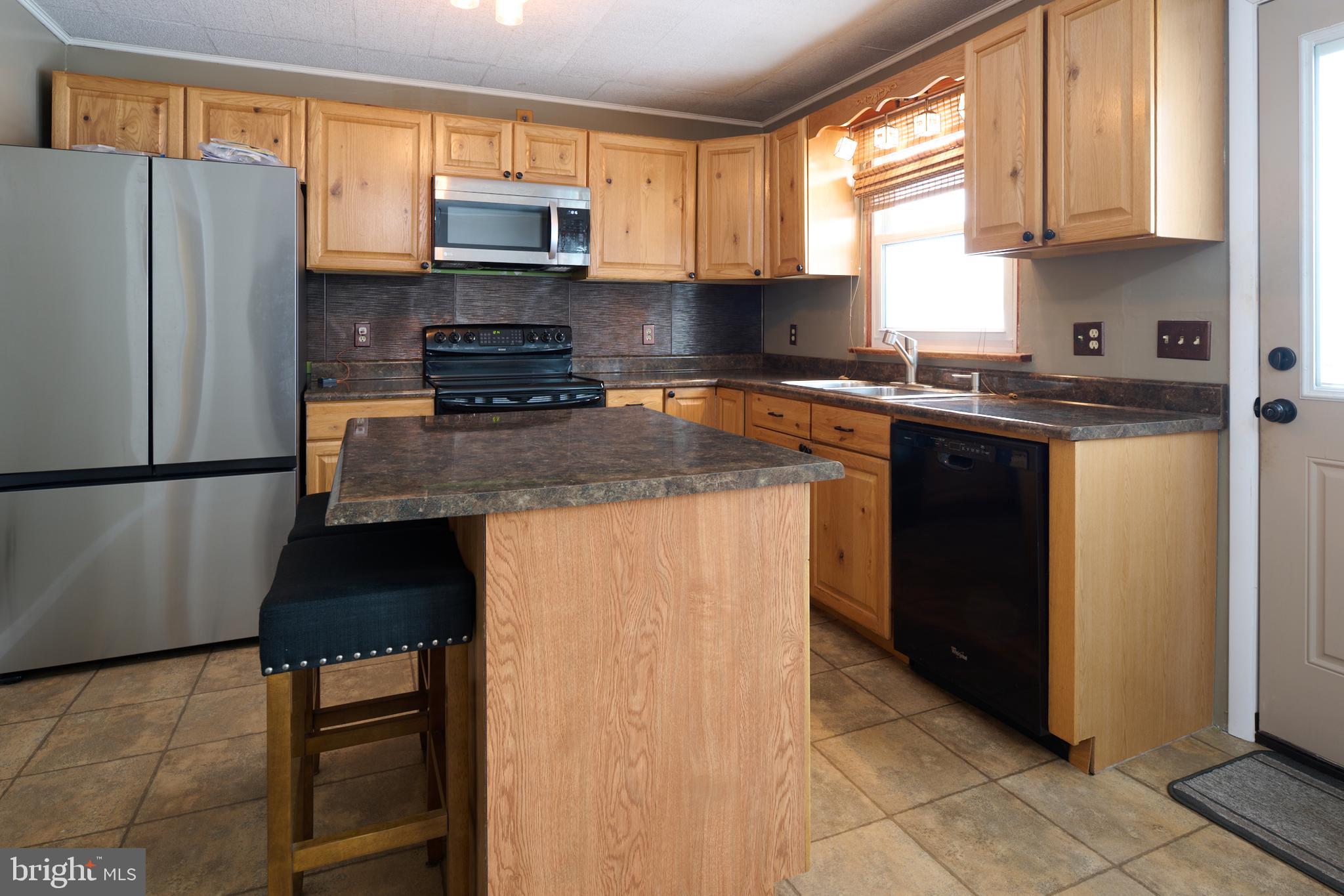 574 Buffalo Run Road Bellefonte, PA 16823 - Photo 7 of 54 a kitchen with stainless steel appliances granite countertop a stove a refrigerator a sink and a microwave