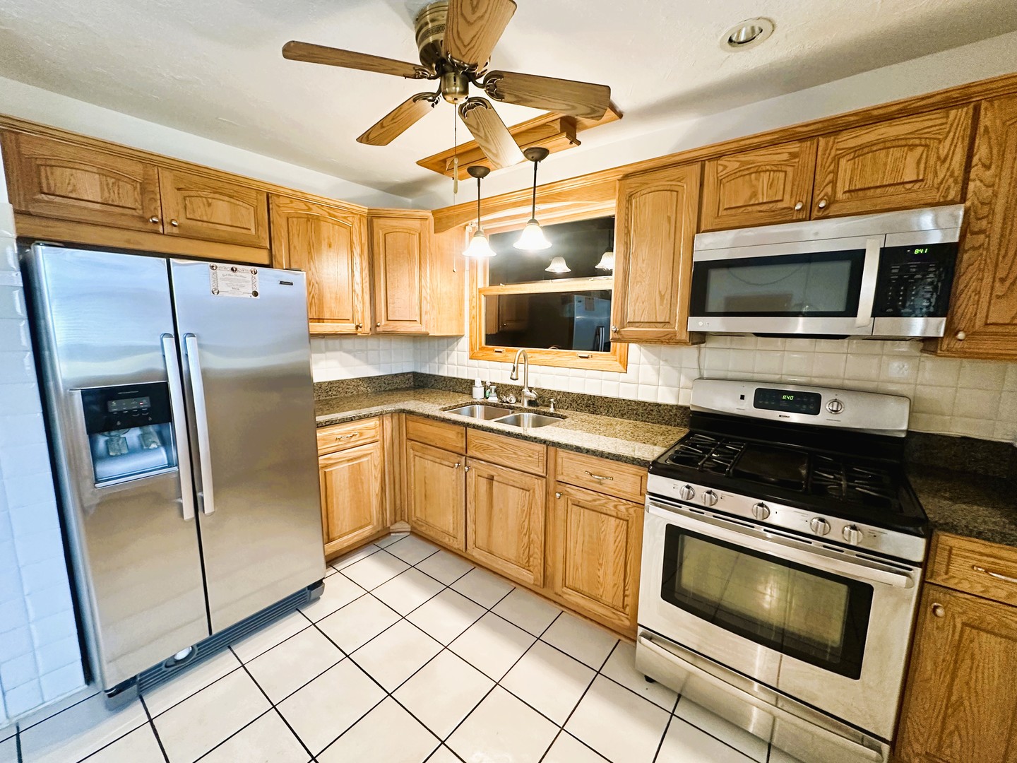 9112 Homestead Lane Bridgeview, IL 60455 - Photo 11 of 29 a kitchen with stainless steel appliances granite countertop a stove a microwave and a refrigerator