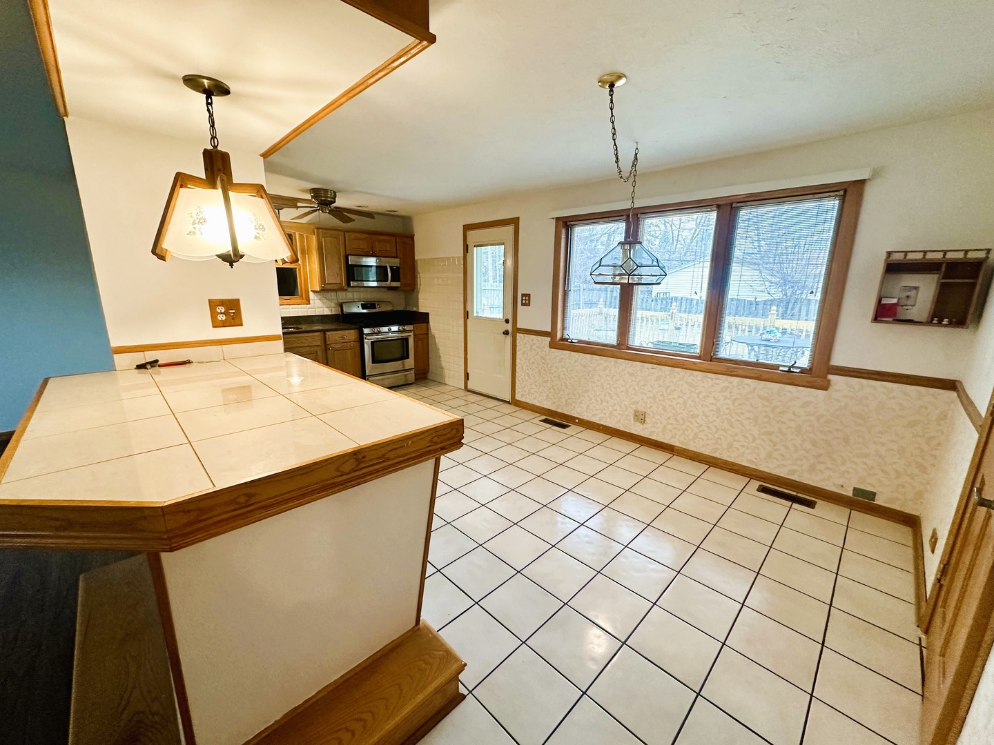 9112 Homestead Lane Bridgeview, IL 60455 - Photo 9 of 29 a kitchen view with a stove a refrigerator and a dining table with wooden floor