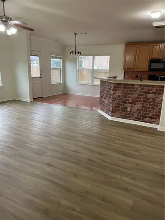 a view of a kitchen with kitchen island a sink wooden floor and a counter top space