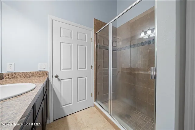 a bathroom with a shower a sink and a mirror