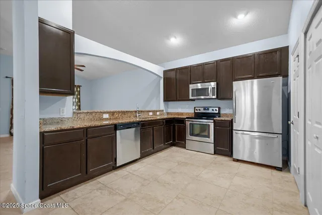a kitchen with granite countertop stainless steel appliances and refrigerator