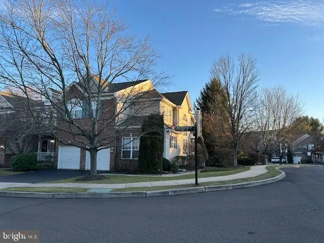 a white house that has a tree on the side of it