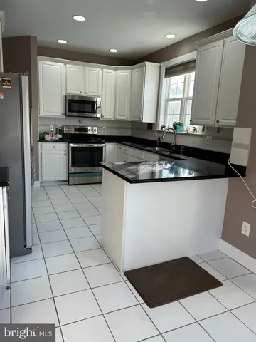 a kitchen with stainless steel appliances a sink a stove a microwave and a refrigerator