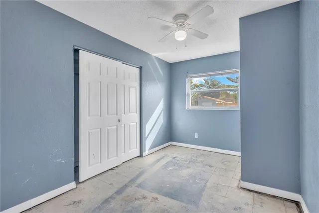 an empty room with windows and closet