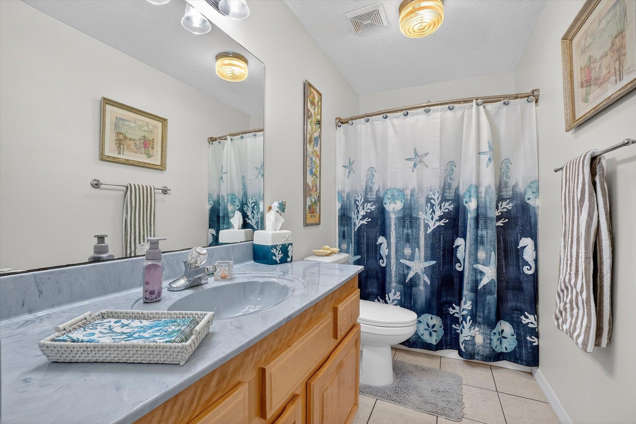 229 Yale Road St. Augustine, FL 32086 - Photo 23 of 47 Full bathroom featuring vanity, a shower with curtain, light tile patterned flooring, and a textured ceiling