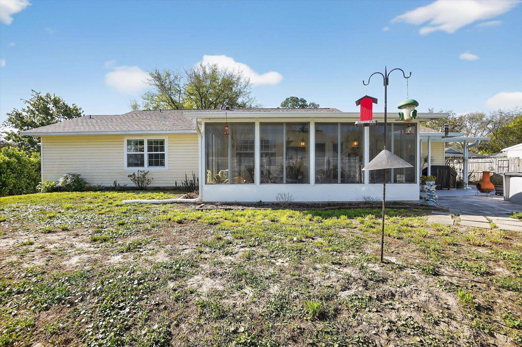 229 Yale Road St. Augustine, FL 32086 - Photo 47 of 47 Rear view of house with a lawn, a sunroom, and a patio