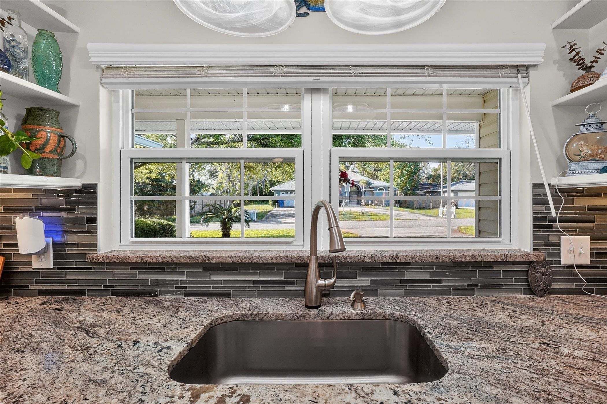 229 Yale Road St. Augustine, FL 32086 - Photo 6 of 47 Kitchen view of open shelves, light stone counters, and backsplash