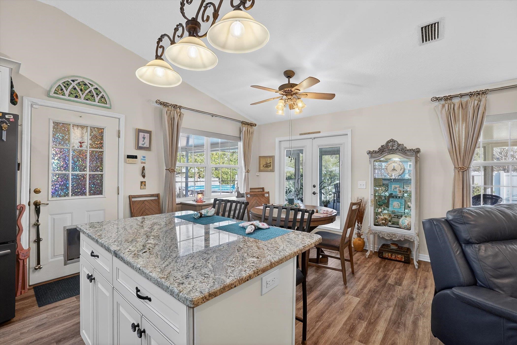 229 Yale Road St. Augustine, FL 32086 - Photo 9 of 47 Kitchen featuring white cabinets, vaulted ceiling, light stone counters, french doors, and a center island