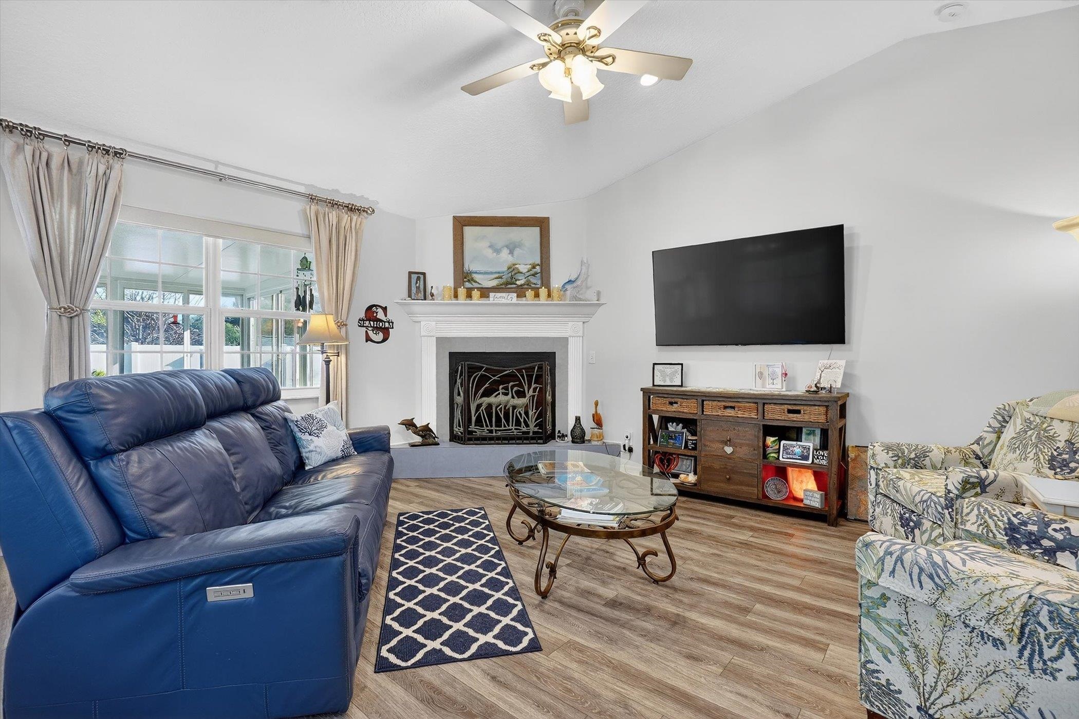 229 Yale Road St. Augustine, FL 32086 - Photo 10 of 47 Living area with wood finished floors, ceiling fan, a fireplace with raised hearth, and vaulted ceiling