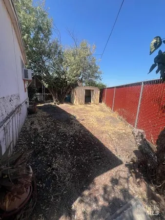 a view of backyard with barbeque grill and wooden fence