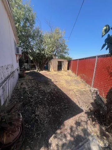a view of backyard with barbeque grill and wooden fence