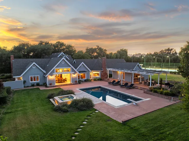 a living room with furniture a fireplace and a chandelier