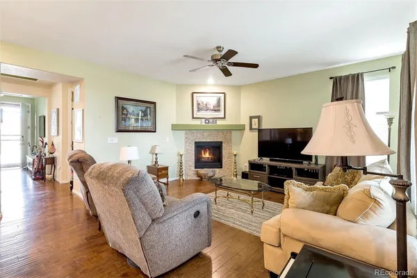 a living room with furniture a large window and a fireplace