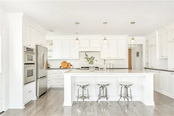 a kitchen with granite countertop white cabinets and refrigerator