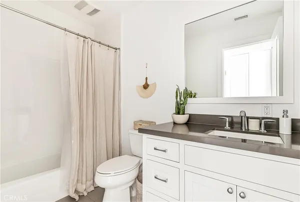 a bathroom with a granite countertop sink a toilet and a mirror