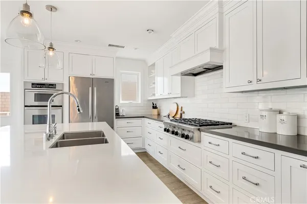 a kitchen with granite countertop a refrigerator stove and sink
