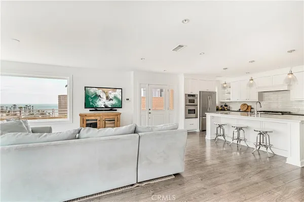 a living room with furniture wooden floor and a large window