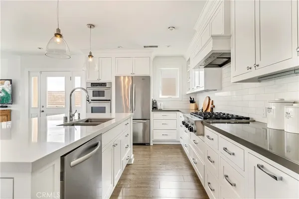 a kitchen with white cabinets and appliances