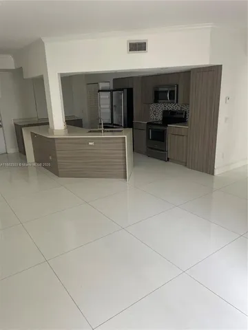 a large kitchen with cabinets and stainless steel appliances
