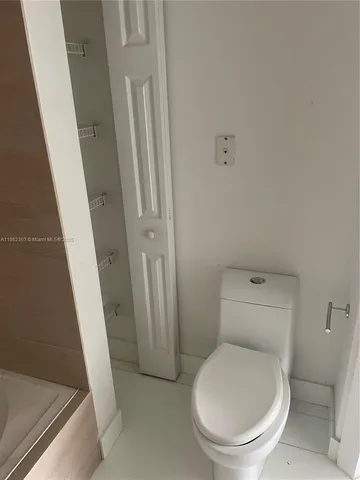 a white toilet sitting next to a sink