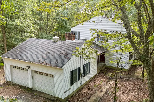 a aerial view of a house with a yard and large trees