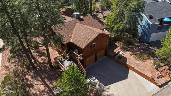 an aerial view of a house with a yard and trees