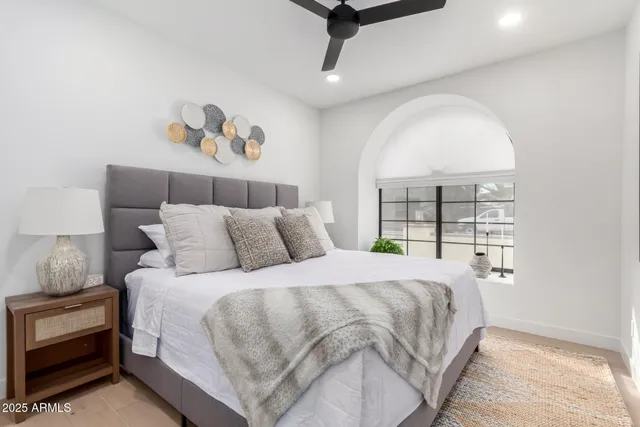 a bedroom with a bed and painting on the wall