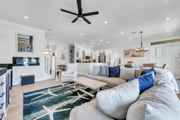 a kitchen with stainless steel appliances kitchen island granite countertop a refrigerator a stove a sink dishwasher and white cabinets with wooden floor