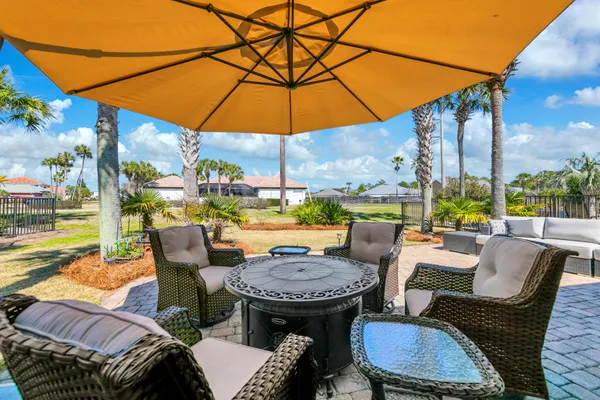 a view of a patio with table and chairs under an umbrella
