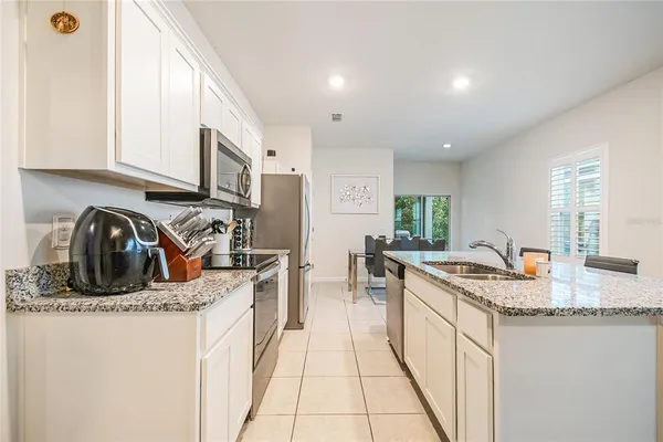 a kitchen with stainless steel appliances granite countertop a sink stove and cabinets