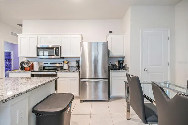 a kitchen with granite countertop a refrigerator stove top oven and sink