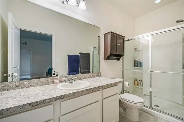 a bathroom with a granite countertop sink toilet and shower