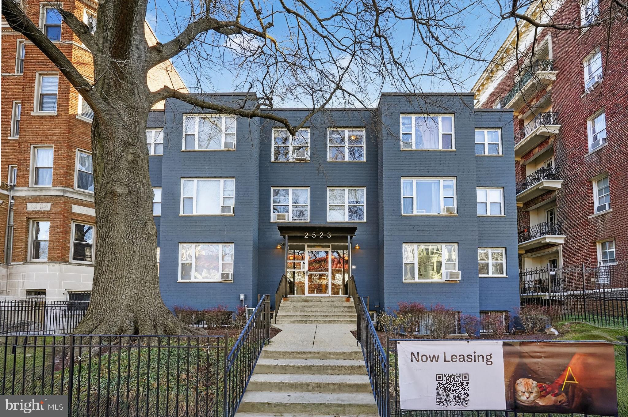 a front view of a residential apartment building with a yard