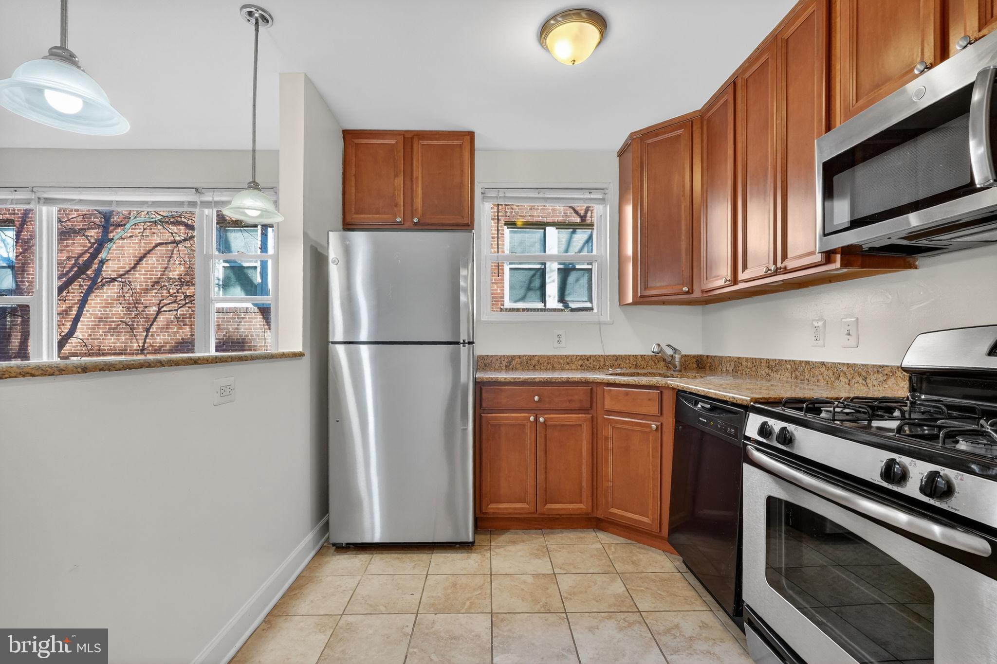 2523 13th Street Northwest, Unit 305 Washington, DC 20009 - Photo 11 of 29 a kitchen with stainless steel appliances granite countertop a refrigerator stove and microwave