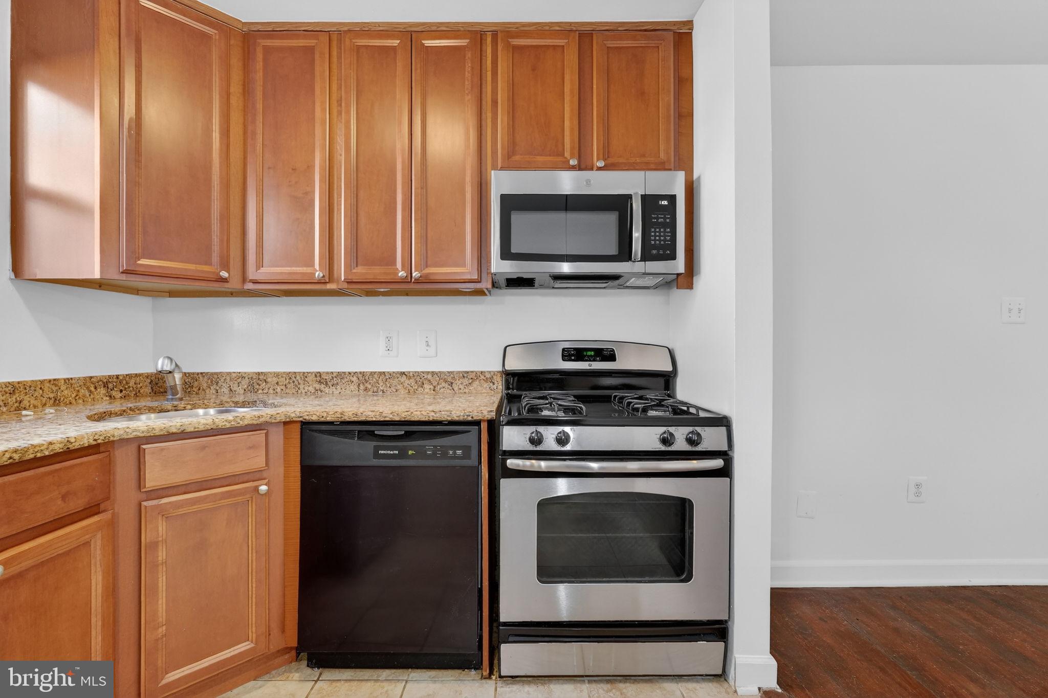 2523 13th Street Northwest, Unit 305 Washington, DC 20009 - Photo 13 of 29 a kitchen with a stove and a microwave