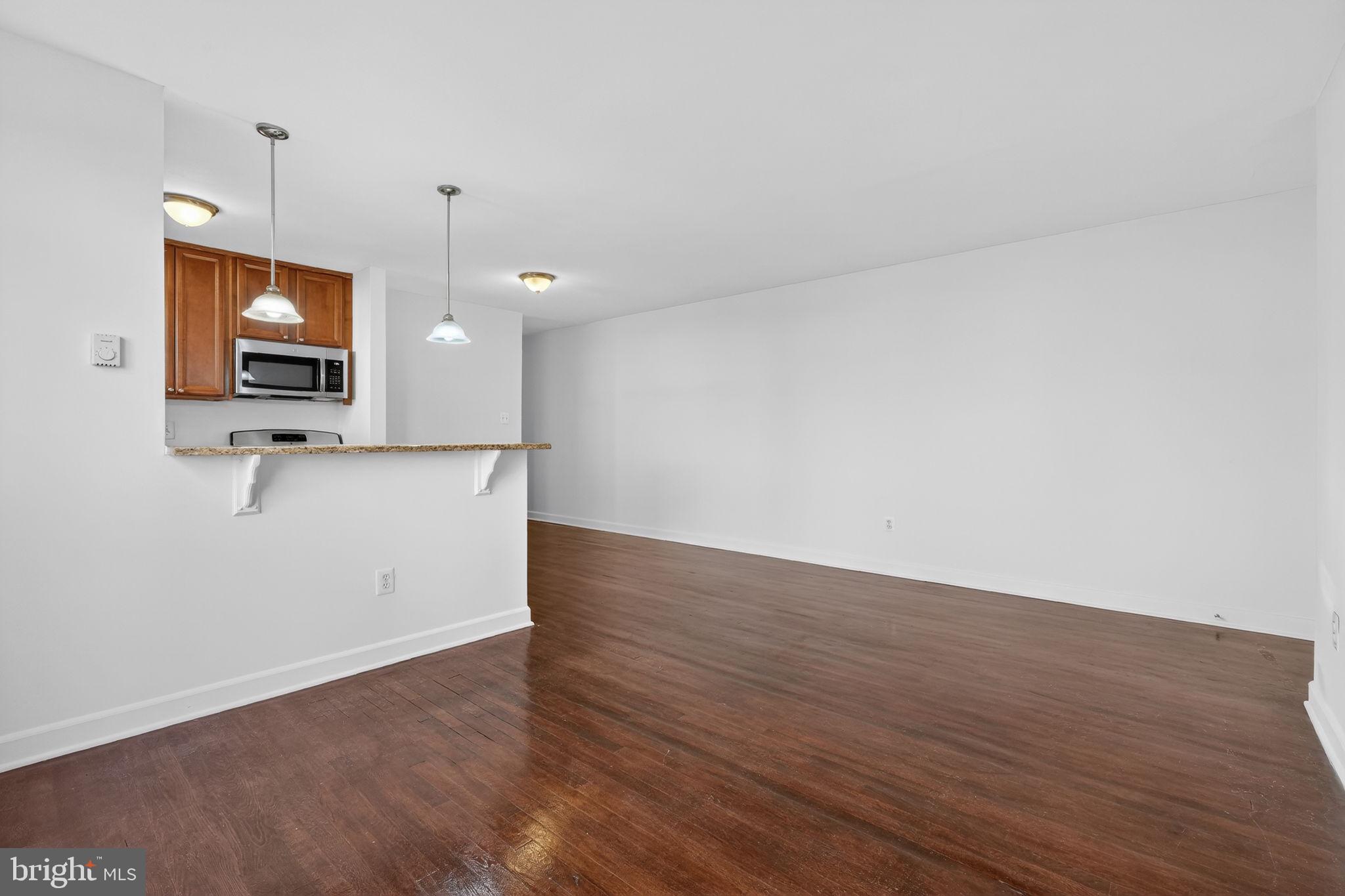 2523 13th Street Northwest, Unit 305 Washington, DC 20009 - Photo 7 of 29 a view of a room with wooden floor and flat screen tv