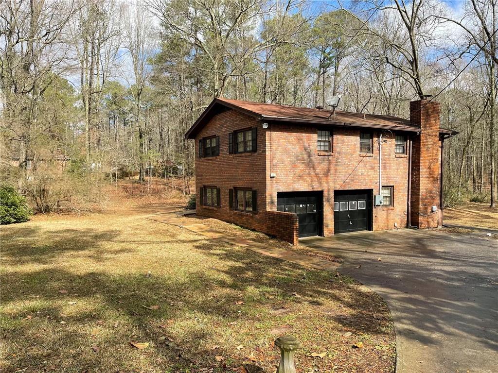 a view of house with backyard and trees
