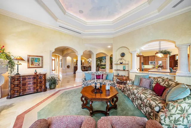 a view of a dining room with furniture a chandelier and large windows