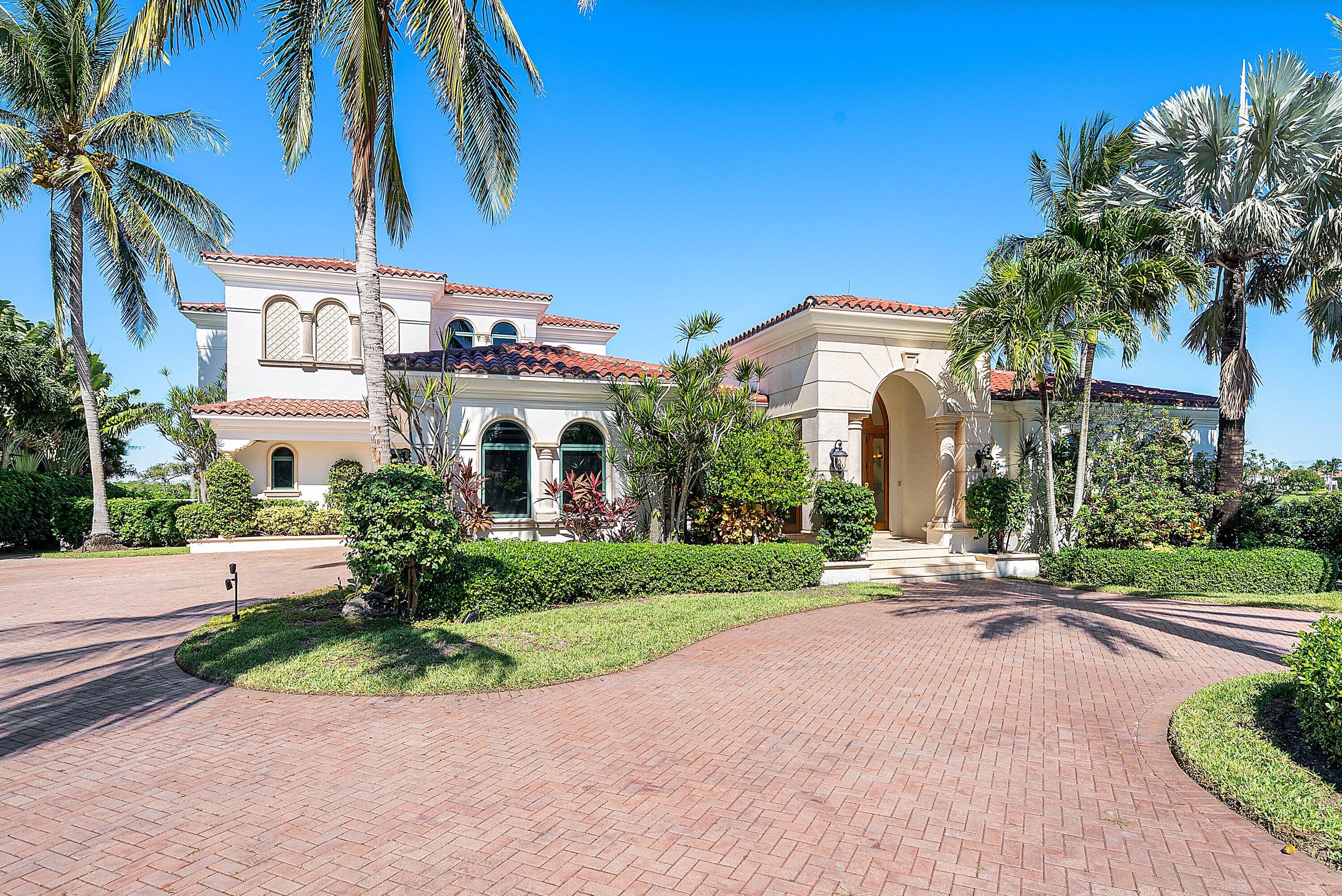 6381 Southeast Harbor Circle Stuart, FL 34996 - Photo 4 of 102 a front view of a house with a yard and potted plants