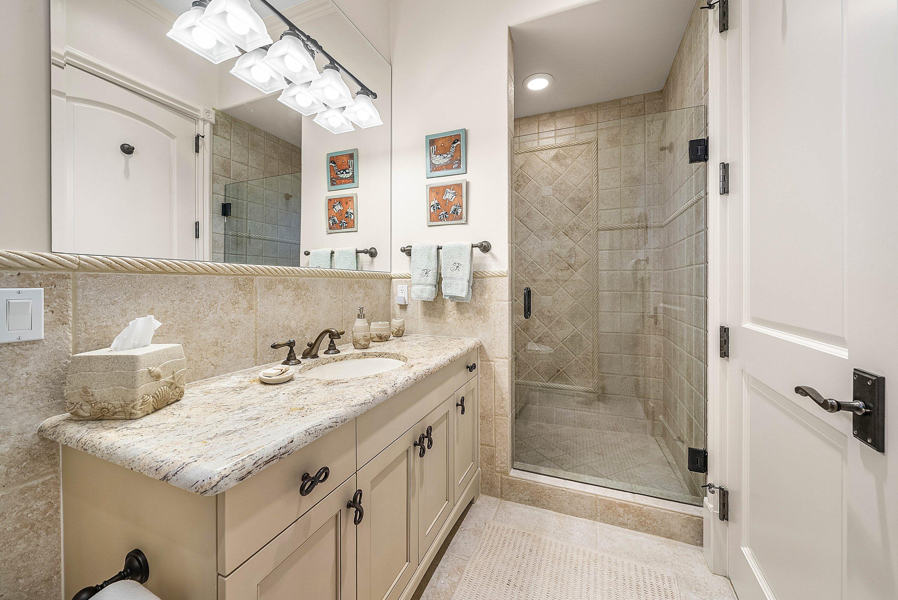 6381 Southeast Harbor Circle Stuart, FL 34996 - Photo 63 of 102 a bathroom with a granite countertop sink a mirror and a shower